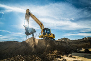 Construction – digger working at building site on sunny day